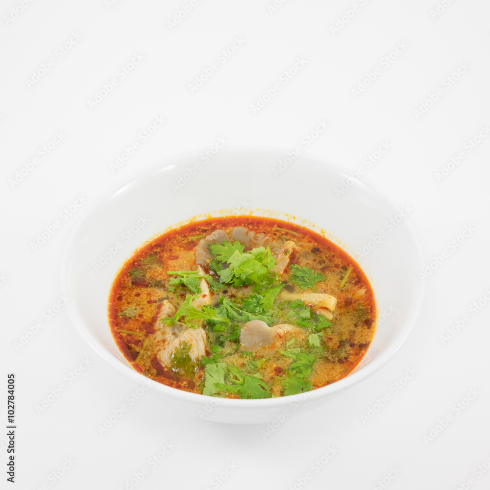 The tasty spicy pork tom yum soup (hot and sour soup) in white ceramic bowl, homemade Thai food.