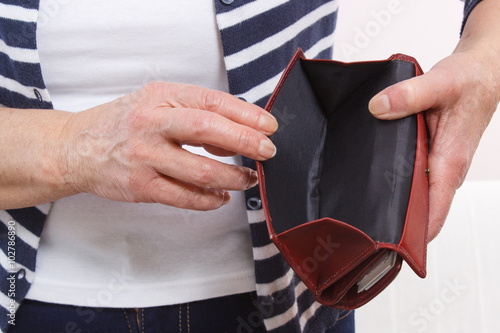 Hands of senior woman showing empty wallet, concept of financial security in old age
