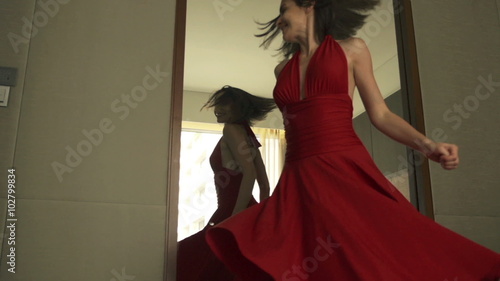 Young, beautiful woman checking her appearance in front of the mirror
