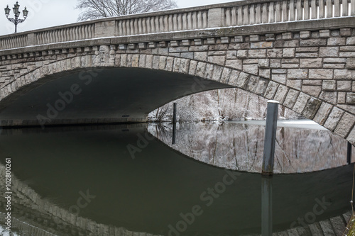 winter view of a frozen river under a bridge