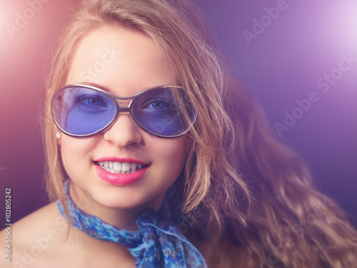 Young cheerful girl with party lights, in old fashioned retro sunglasses and scarf © steevy84