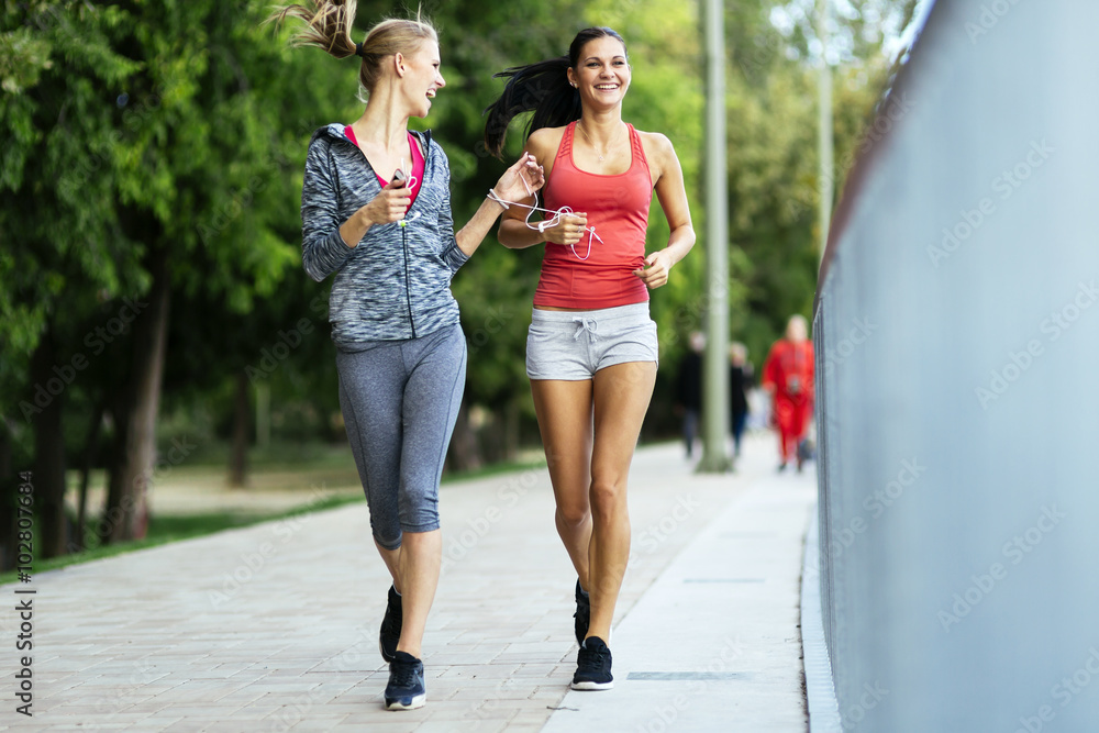 Fit women jogging outdoors