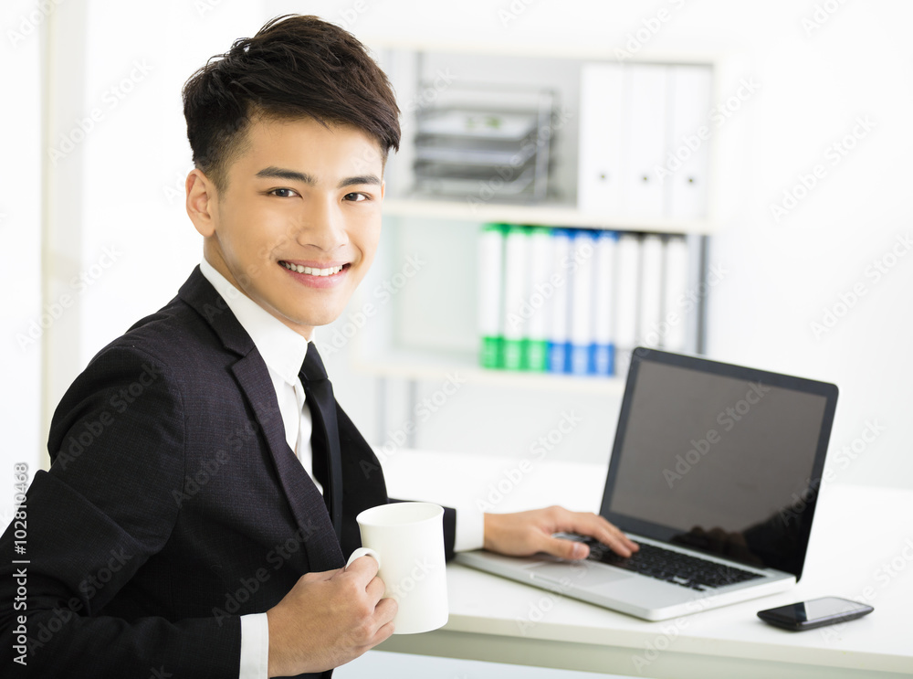 happy young businessman with laptop in office happy young businessman with laptop in office