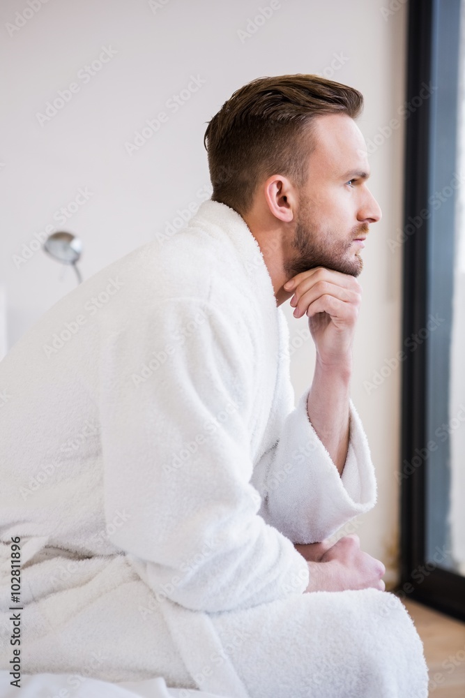 Serious man in bathrobe looking away Serious man in bathrobe looking away