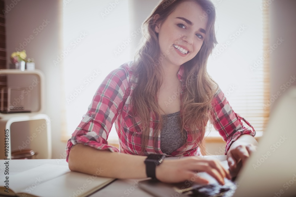 Smiling hipster businesswoman working on computer