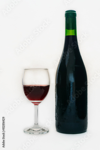 Red wine in a glass and in wine bottle on white background