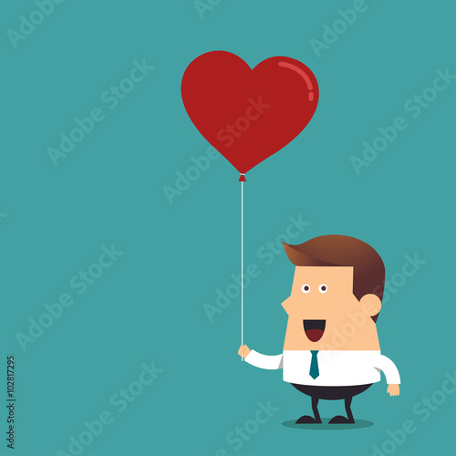 Young businessman holding red heart shaped balloon