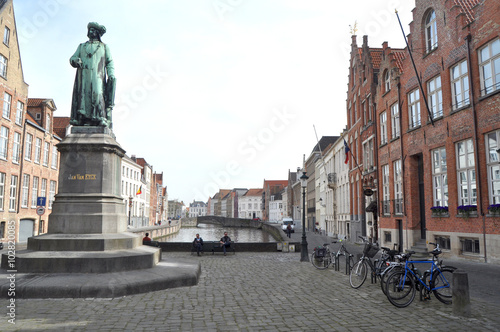 A typical street with traditional houses with statue in Bruges Belgium 