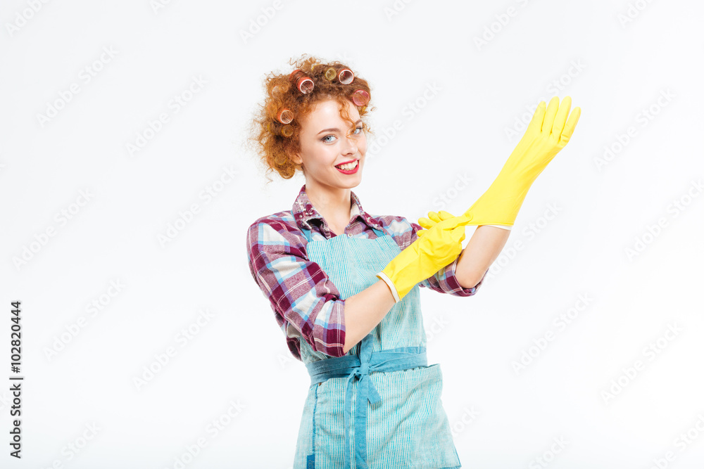 Happy housewife in blue apron wearing yellow gloves Happy housewife in blue apron wearing yellow gloves