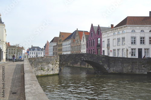 Panoramic view along one of the many canals in Bruges Belgium flanked by characteristic old buildings