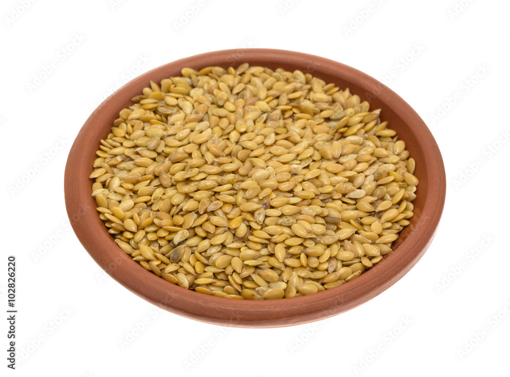 Bowl of organic golden flaxseed on a white background