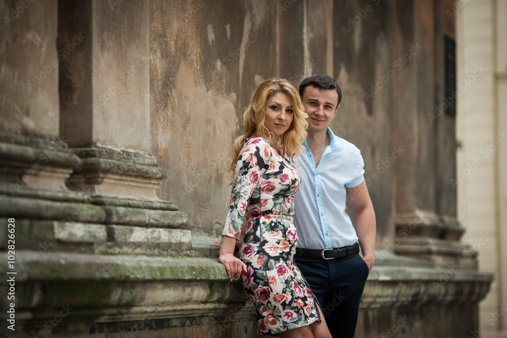 Happy elegant dressed couple posing near old church Happy elegant dressed couple posing near old church