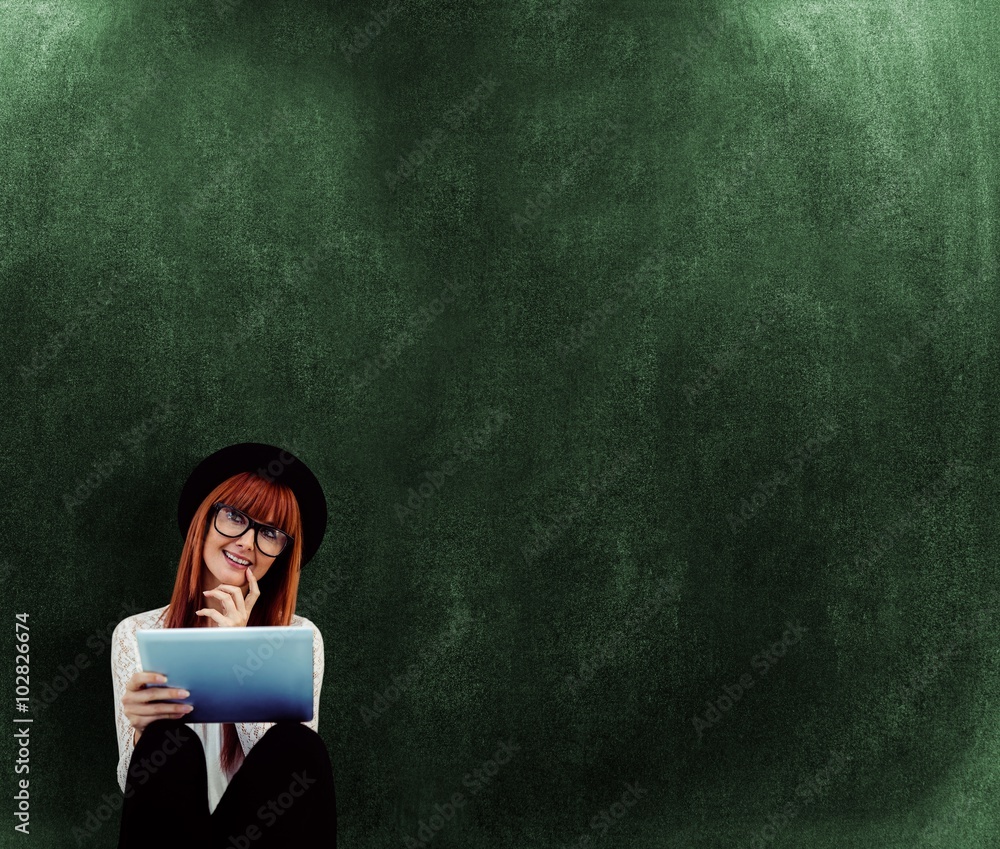 Composite image of smiling hipster woman using her tablet Composite image of smiling hipster woman using her tablet