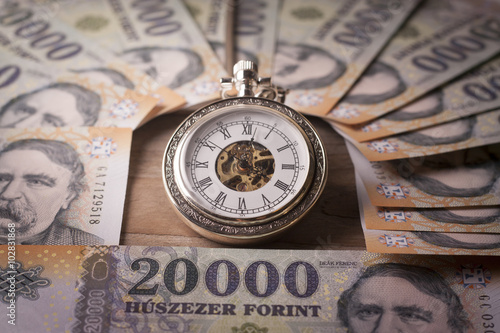 Money , retro clock  on a wooden table - Time is money concept