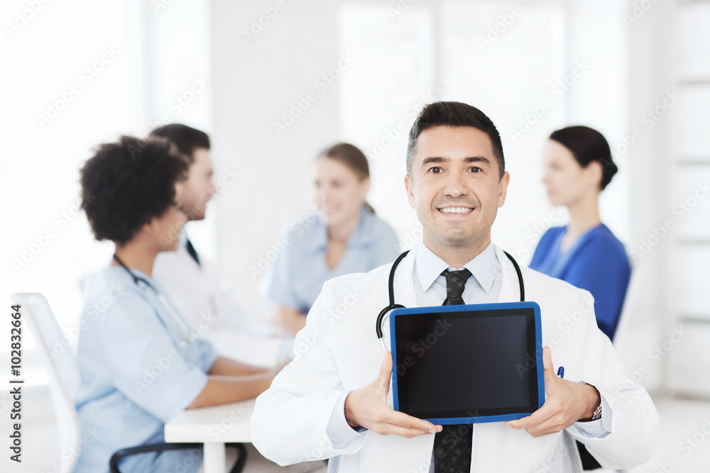 happy doctor with tablet pc over team at clinic happy doctor with tablet pc over team at clinic