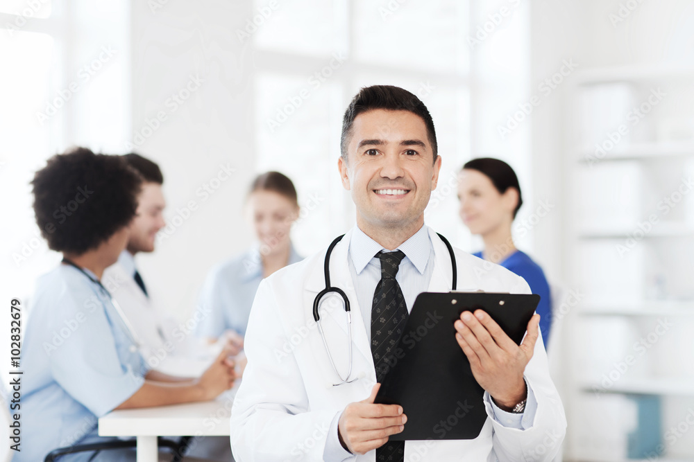 happy doctor with clipboard over medical team happy doctor with clipboard over medical team