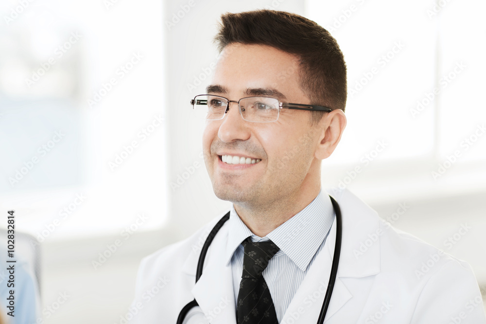 smiling male doctor in white coat and eyeglasses smiling male doctor in white coat and eyeglasses