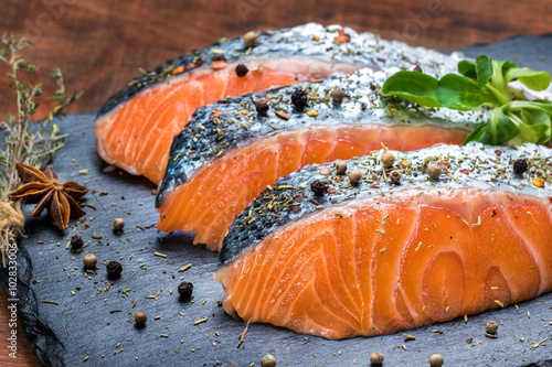 Fresh salmon portions with herb and pepper seasoning. photo