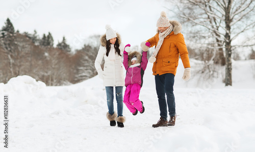 happy family in winter clothes walking outdoors