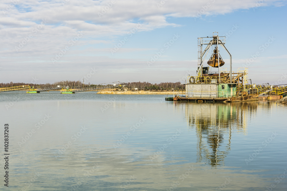 Dredger in the gravel pit water. Dredger in the gravel pit water.