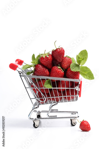 Shopping cart filled with fresh strawberries isolated over white. Healthy shopping and eating concept.Close up.