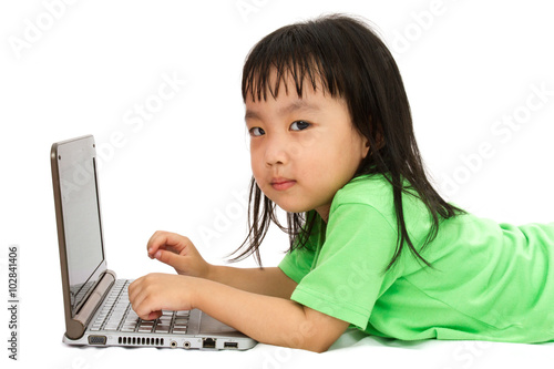 Chinese little girl lying down with laptop