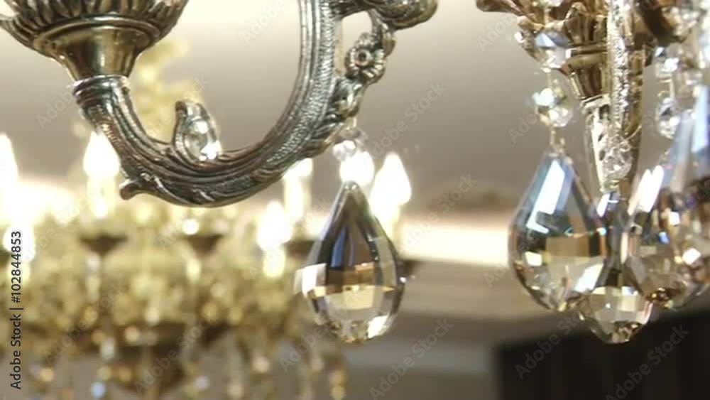 Beautiful crystal chandelier on the ceiling. View showcase of modern elegant luxury apartment interior design decoration of area living rooms in stylish contemporary feel house. Home furnishings. Beautiful crystal chandelier on the ceiling. View showcase of modern elegant luxury apartment interior design decoration of area living rooms in stylish contemporary feel house. Home furnishings.