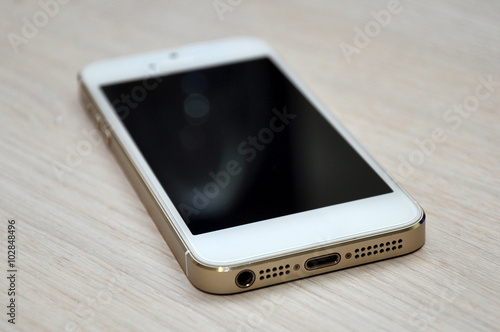 Blank screen mobile phone on wood background