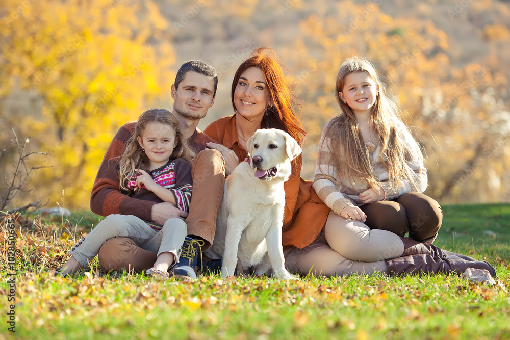 Obraz premium Happy family on nature with a labrador