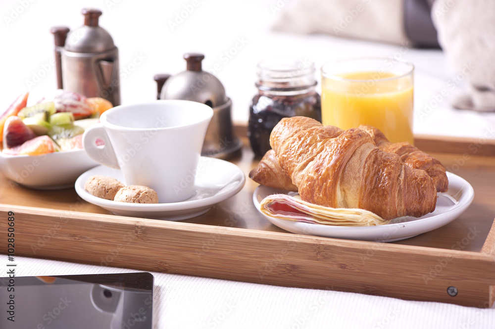 Tray with breakfast on a bed in a hotel room Tray with breakfast on a bed in a hotel room