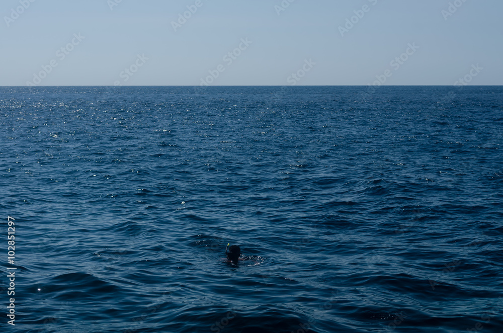 Scuba diver in vast and ocean on the surface