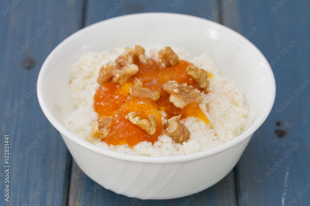 fresh cheese with pumpkin jam and nuts in bowl on blue background fresh cheese with pumpkin jam and nuts in bowl on blue background