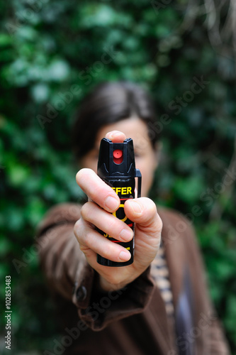 Frau hält drohend Pfefferspray in die Kamera