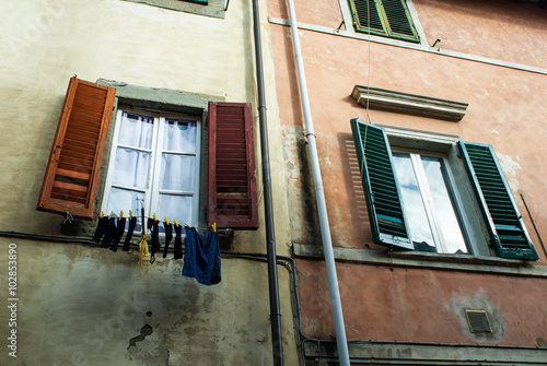 Fotografie Finestre e bucato di panni lavati stesi, vestiti appesi