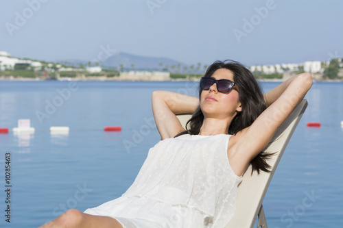 beautiful young woman relaxing on a sunbed on a sea background.Summer holiday © boryanam