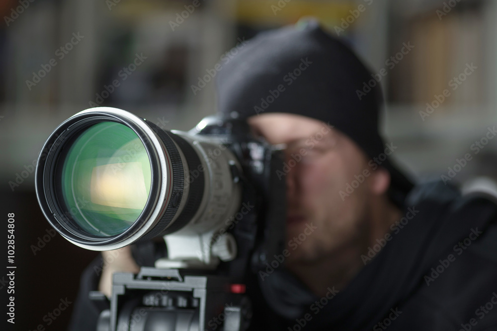 Man taking pictures with large telephoto lens Man taking pictures with large telephoto lens