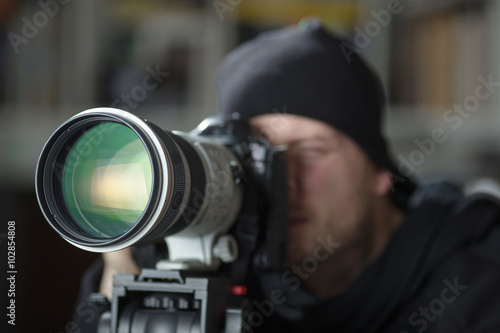 Photography Man taking pictures with large telephoto lens