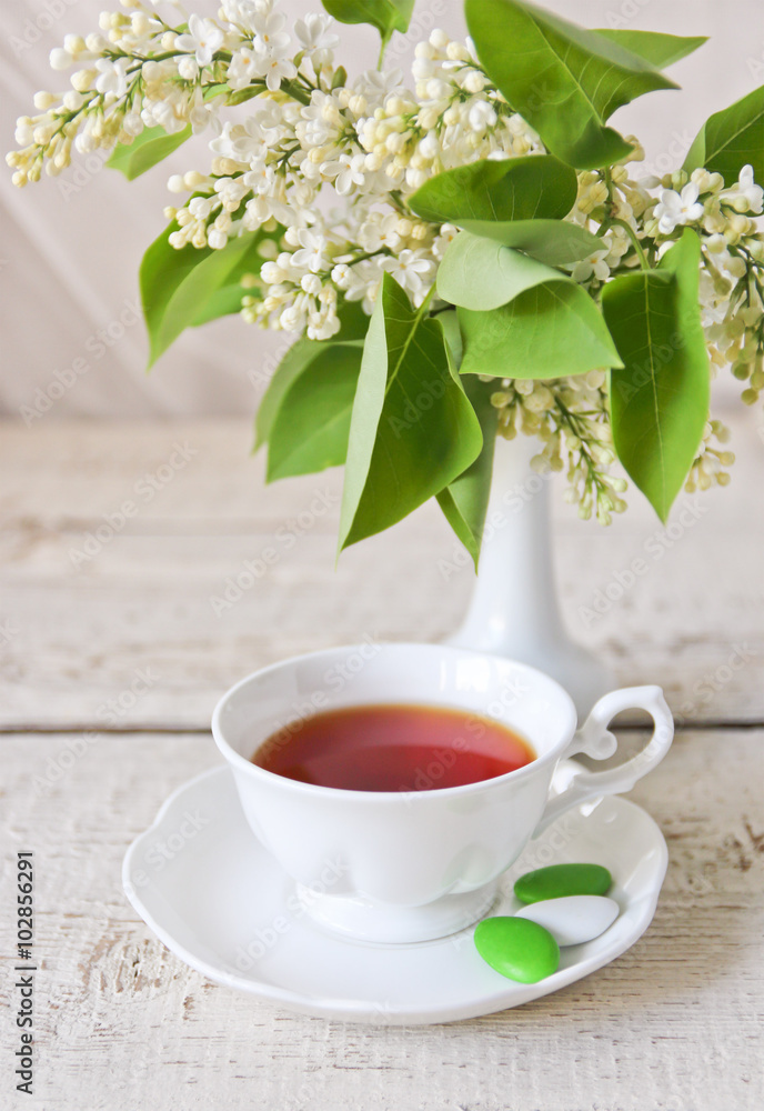 cup of tea and a bouquet of white lilac in the vase cup of tea and a bouquet of white lilac in the vase