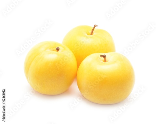 Three yellow plums isolated on white background