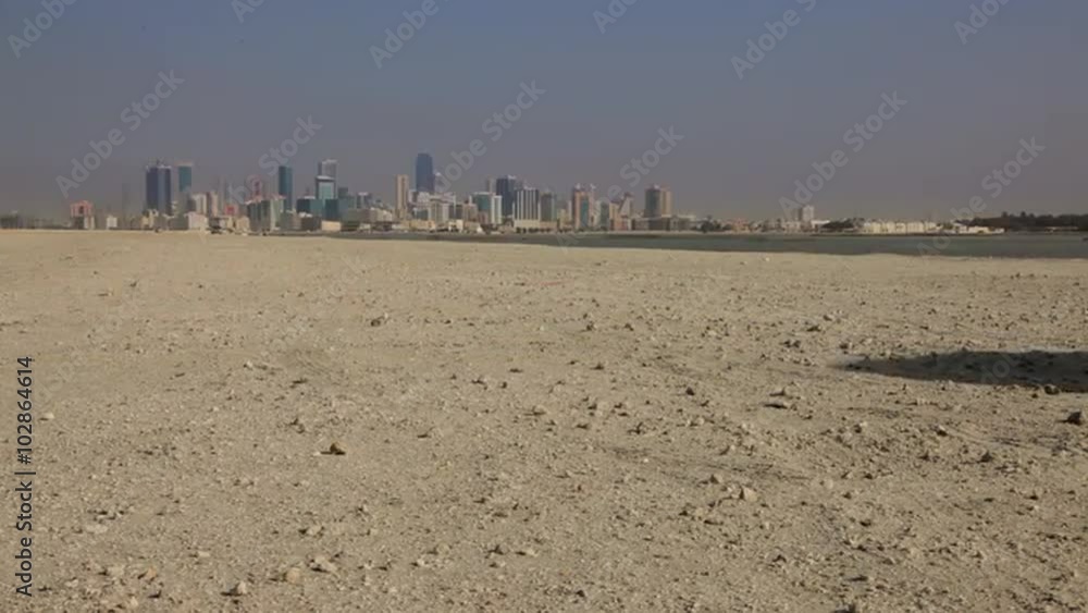 Manama Skyline from the desert. A Car crossing the frame Manama Skyline from the desert. A Car crossing the frame