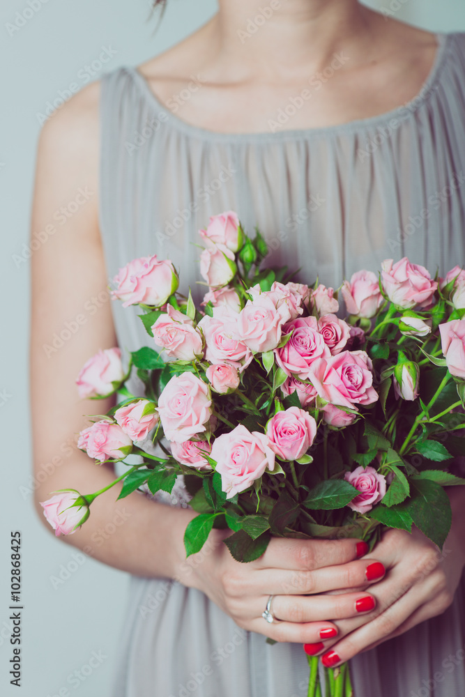 Wedding bouquet of flowers, young bridesmaid holding a bouquet of pink roses. 