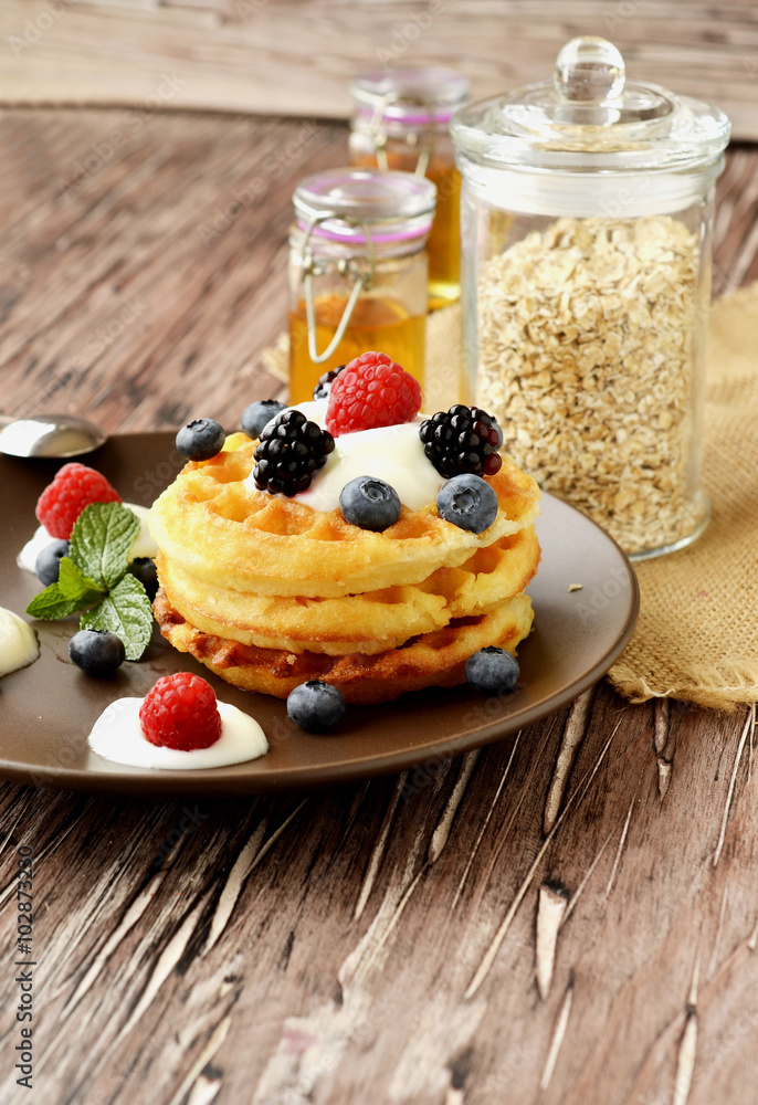 Belgian waffles with berries and honey selective focus