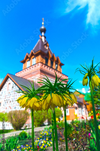 Spring blooming flowers against background of the brick Church