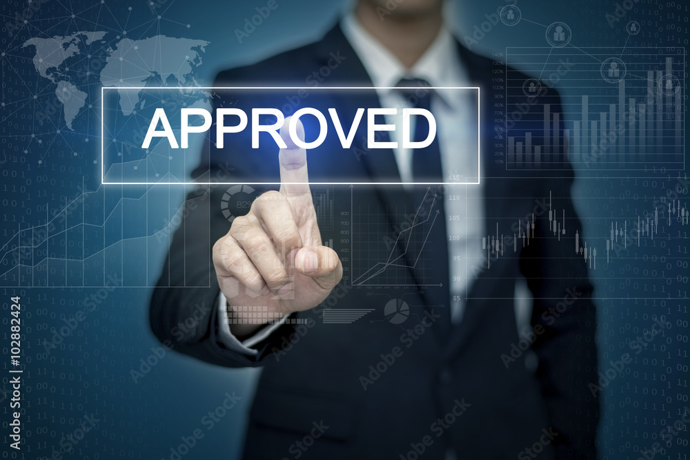 Businessman hand touching APPROVED button on virtual screen Businessman hand touching APPROVED button on virtual screen