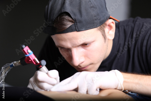 Tattooist makes tattoo, clo...
