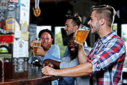 Young men drinking beer in pub