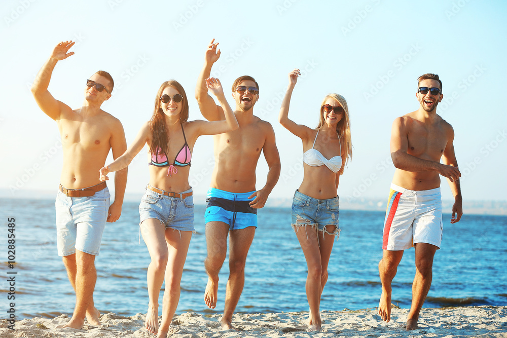 Happy friends running at the beach, outdoors Happy friends running at the beach, outdoors