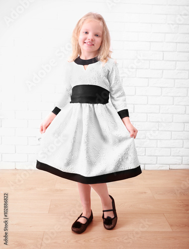 Wallpaper Mural Little girl in dress on a white brick wall background Torontodigital.ca