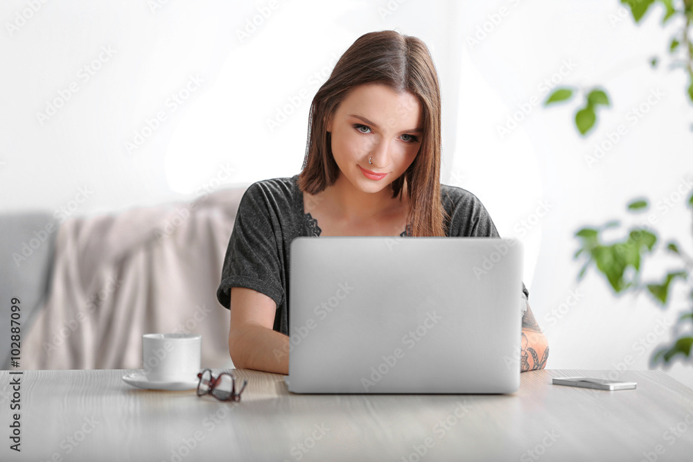 Woman sitting at the table and working with laptop Woman sitting at the table and working with laptop