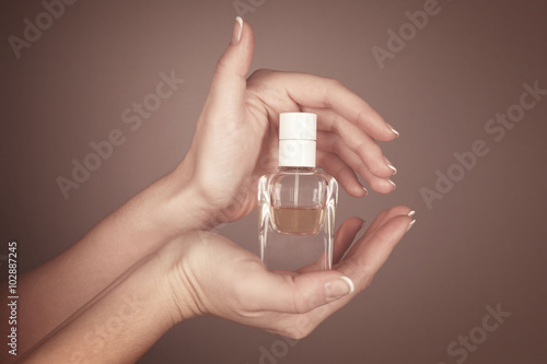 Young woman holding bottle perfume